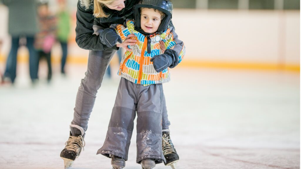 mother helping her son learn to ice skate picture id494705652